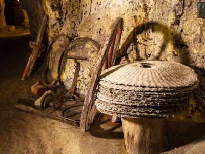 Nella pressa del macchinario troviamo dei fiscoli, i dischi in fibra che si usavano per separare l�olio dalla sansa. Accanto, si addossano al muro delle grandi ruote da carrozze e vecchi utensili per lavorare la terra
